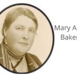 imagem de Mary Ann Baker - preto e branco - com brincos, colares e cabelo liso penteado no meio, séria